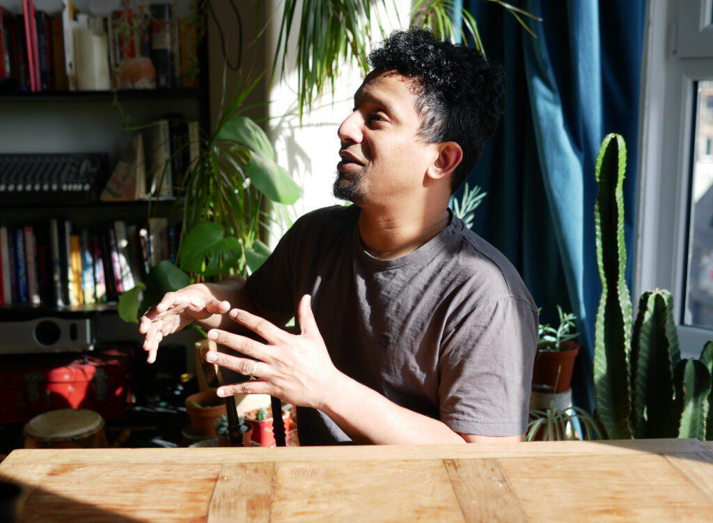 Man gesturing with his hands sitting at a table