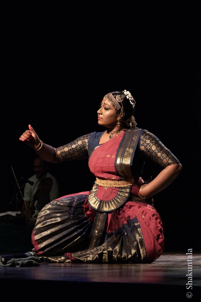 Woman dancer kneeling and gesturing with hand and finger